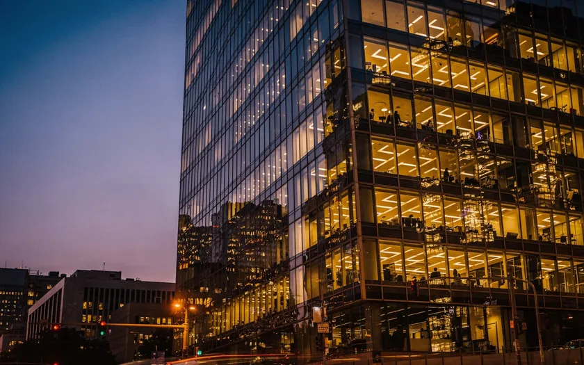 Modernt kontorsbyggnad i skymning med upplysta fönster